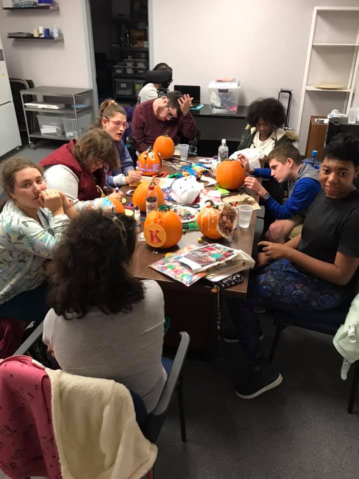 A group of kids carving pumpkins