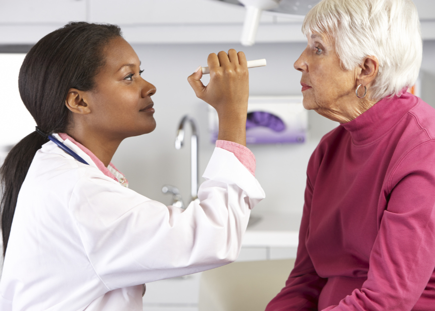 Doctor Examining Senior Female Patient's Eyes